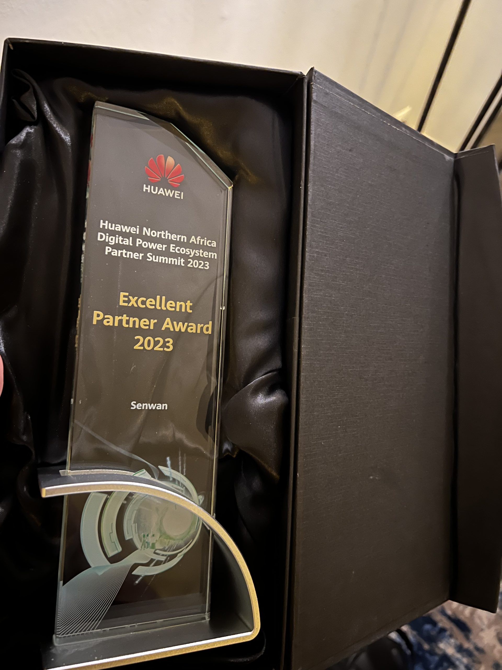 Hamza Krir, CCO of Senwan Group, proudly holds the “Excellent Partner Award 2023” plaque at the Huawei Northern Africa Digital Power Ecosystem Partner Summit 2023, surrounded by industry representatives and digital conference displays, highlighting innovation and collaboration in the digital power sector.
